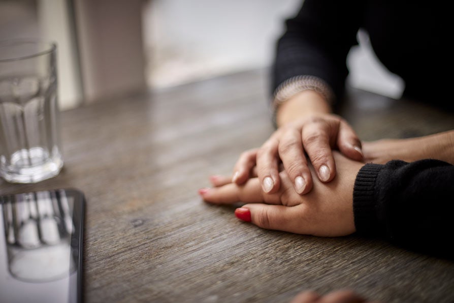 Close up of hands holding on top of table
