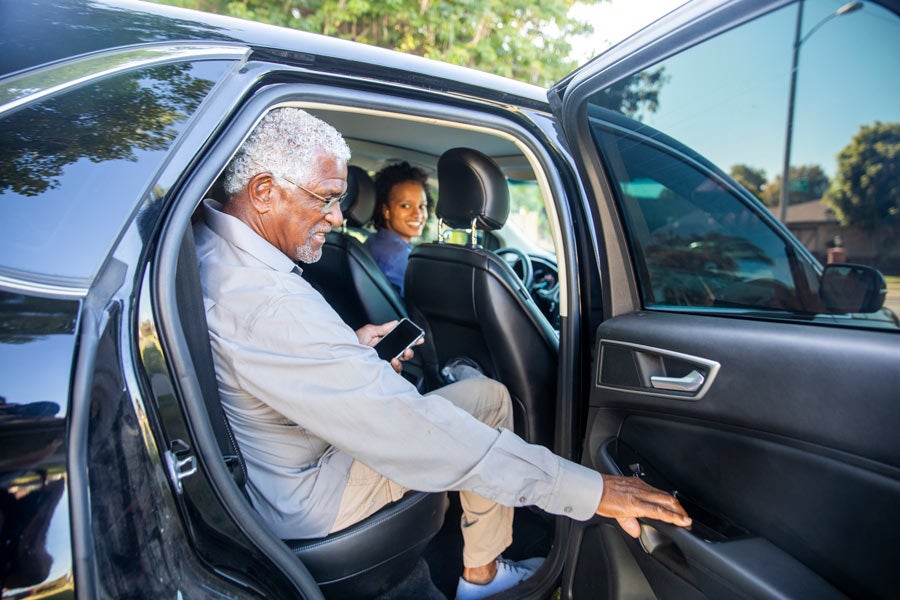 Senior African American man gets in taxi